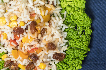 rice with yellow and red pepper and dried grapes on the Savoy cabbage leaf, rice put in vegetable sheet