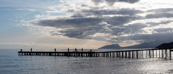 Fototapeta na wymiar fishermen on a pier in the sea