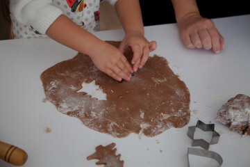 Caucasian mother and daughter cooking ginger bread in the kitchen. Christmas cooking concept. Mother and daughter cooking concept. 