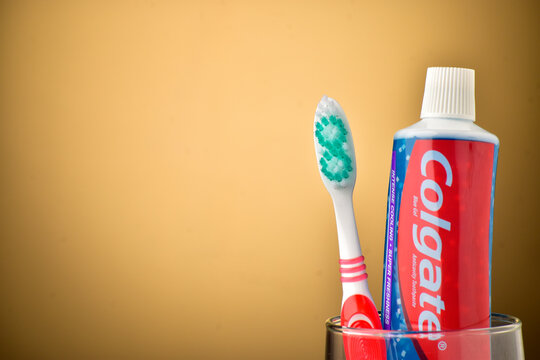 colgate toothpaste with tooth brush on brown background with copyspace
