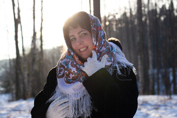 happy woman in a body in nature in winter in a beautiful headscarf