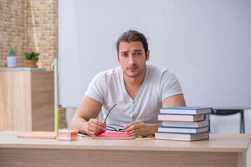 Young male teacher student sitting in the classroom