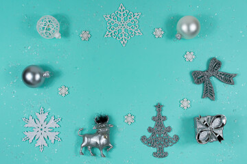 A toy bull on a blue background stands in the snow with a gift and a ball. The symbol of the new...