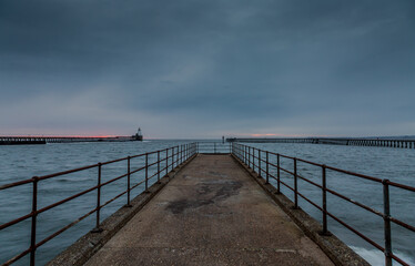 Obraz premium Morning at Blyth beach in Northumberland, England, with the old wooden Pier stretching out to the North Sea