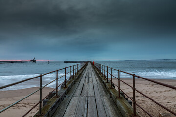 Obraz premium Morning at Blyth beach in Northumberland, England, with the old wooden Pier stretching out to the North Sea