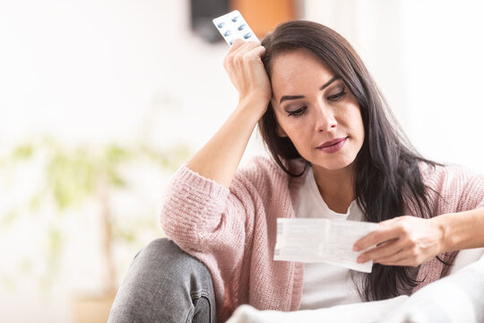 Worried Expression On A Face Of A Woman Reading A Label Of Medication Packaging