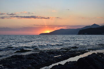 Red sunset on the sea.Stone beach