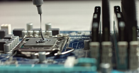 Build computer concept. Close-up shot of applying thermal paste on cpu. 4k footage. Close-up of smudging hermal paste on processor of notebook with spoon. Thermal grease for better cooling of device