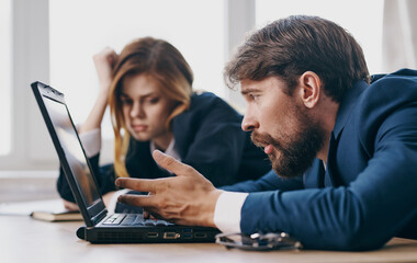 tired man and woman at work colleagues at work laptop professionals