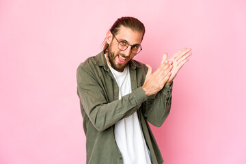 Young man with long hair look feeling energetic and comfortable, rubbing hands confident.