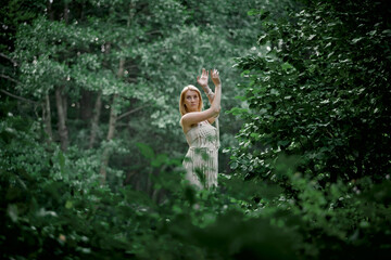 Beautiful young woman doing yoga in nature. Clothing made of eco-friendly materials in beige and macrame.