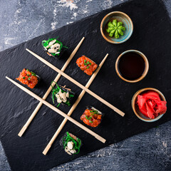 tic tac toe sushi on dark background creative concept sushi, Japanese set sushi Maki rolls on a...