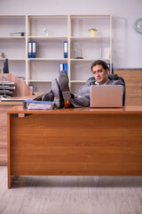 Young male employee sleeping at workplace