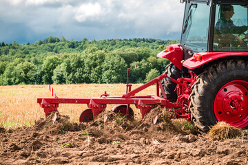 Obraz premium Farmer in tractor preparing land for sowing, plowing the field