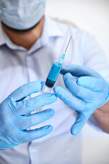 Pandemic concept, close up of scientist injecitng vaccine. Doctor, nurse, scientist hand in blue gloves holding flu, measles, coronavirus, covid-19 vaccine disease preparing for people.