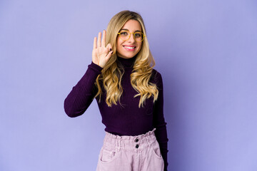 Fototapeta na wymiar Young caucasian blonde woman cheerful and confident showing ok gesture.