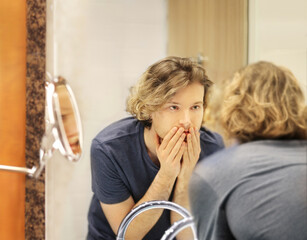 Applying the cream.young man looking in the mirror