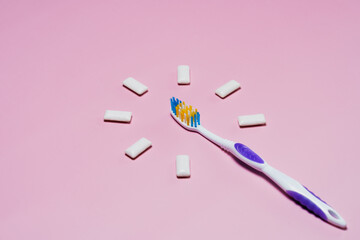 toothbrush and chewing gum pads on a pink background. High quality photo