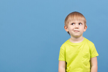 People child looks away, face expresses doubt, disbelief, curiosity, dilemma, guesswork, imagination, planning and mischief. Cunning kid suspects something, copy space.