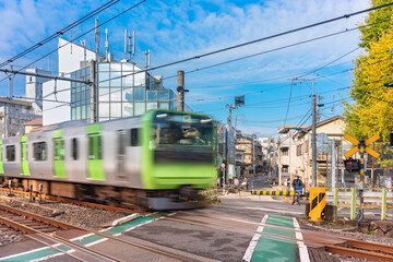 Japan Railway train at fast speed passing over the level crossing of the Yamanote line called...