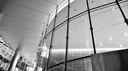 Pattern of office buildings windows illuminated at night. Lighting with Glass architecture facade design with reflection in urban city. Black and white.