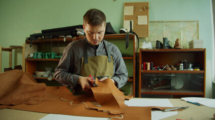 General view of the workshop and workbench of a shoemaker who prepares natural leather to create an exclusive product for his private store.