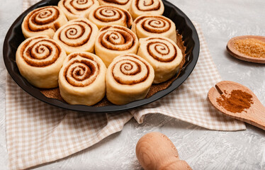 Raw cinnabon buns with cinnamon on ultimate grey backdrop. Ingredients and recipe. Christmas bakery. Flatlay. Kitchen appliances.