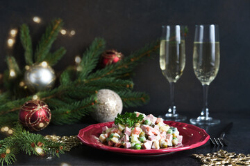 Traditional New Year's salad Olivier. New Year's festive table and glasses of champagne.