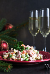 Traditional New Year's salad Olivier. New Year's festive table and glasses of champagne.