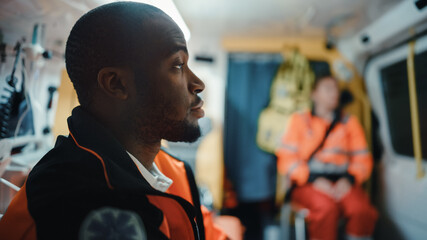 Tired Black African American Paramedic Tries to Rest in an Ambulance Vehicle Going for Emergency....