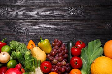 Obraz na płótnie Canvas Assortment of fresh organic fruits and vegetables on black wooden table, flat lay. Space for text