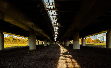 Urban view under the highway overpass with going down sun lights