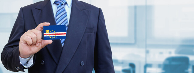 Cropped image of businessman holding plastic credit card with printed flag of Cape Verde....