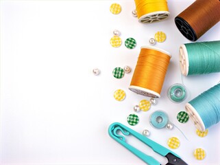 sewing thread and green needle ,Sewing spool of thread and scissors isolated on green background	
