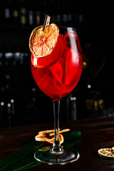 Sangria in glasses with ingredients - orange, lemon and lime slices, dark bar background