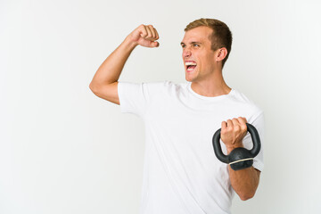 Young caucasian man holding a kettlebell isolated on white background