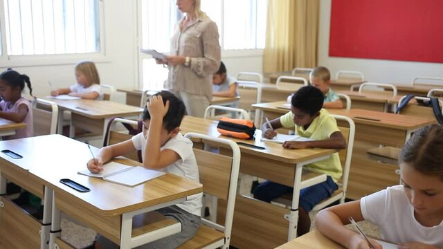 Female teacher and pupils working in classroom at elementary school. High quality FullHD footage