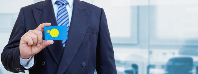 Cropped image of businessman holding plastic credit card with printed flag of Palau. Background...