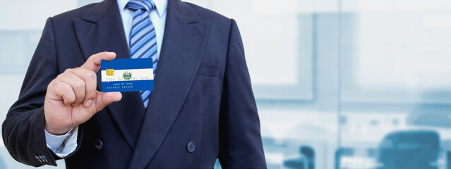 Cropped image of businessman holding plastic credit card with printed flag of El Salvador....