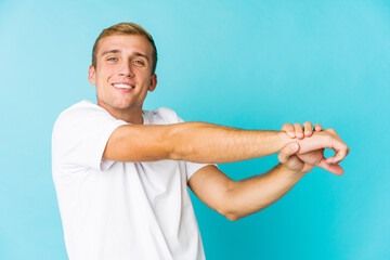 Young caucasian handsome man stretching arms, relaxed position.