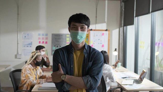 Portrait Young man creative with face mask for protective and prevention covid-19 portrait in office. Working after lockdown