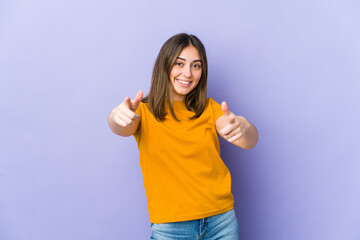 Young caucasian woman cheerful smiles pointing to front.