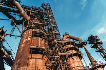 Blast furnace of metallurgical plant or chemical factory, large steel industrial buildings and pipelines.
