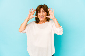Senior caucasian woman isolated receiving a pleasant surprise, excited and raising hands.