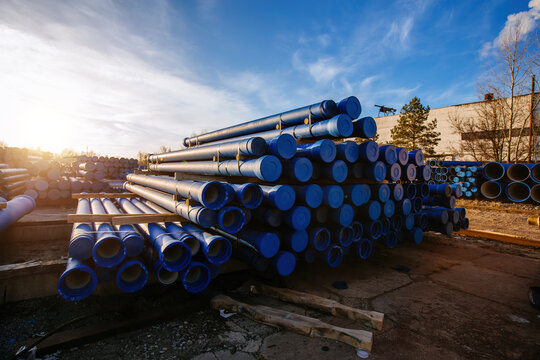 Stack of cast iron pipes in loading area waiting for transportation