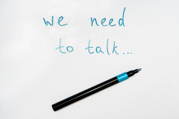 We need to talk message frase written on white piece of paper with a marker, communication problems in family or work office concept