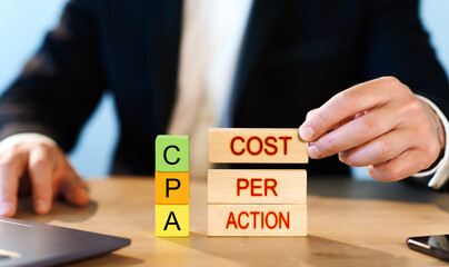 cpa. businessman folds wooden blocks with Cost Per Action inscription