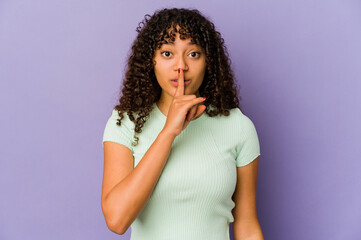 Young african american afro woman isolated keeping a secret or asking for silence.