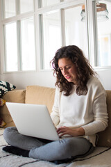 Young woman working from home with laptop