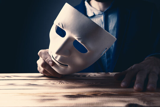 Businessman holding white mask in his hand